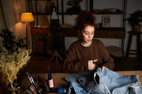 Artisanat upcycles denim dans son espace de travail créatif confortable chaque soir. — Photo de stock