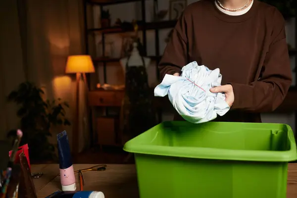 A young woman skillfully folds fabric for her DIY project in a cozy crafting space. — Stock Photo