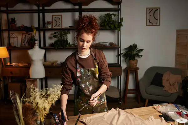 Donna di talento impegnata nel fai da te artigianale in un laboratorio moderno pieno di piante e creatività. — Foto stock