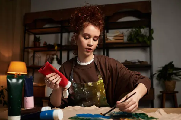 A young woman passionately paints in bold colors, displaying her talent in a chic workshop. — Stock Photo