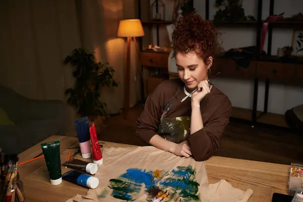 Une jeune femme crée des designs colorés, mettant en valeur son talent dans son espace artistique. — Photo de stock