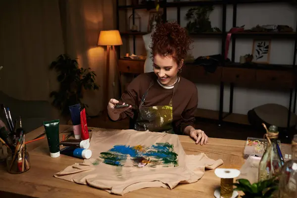 Young woman showcases her art skills by painting on fabric in a modern studio. — Stock Photo