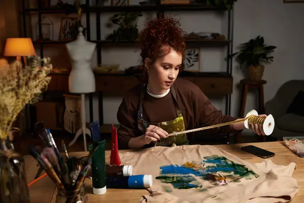 Craftswoman engages in a vibrant DIY project surrounded by art supplies in a stylish room — Stock Photo