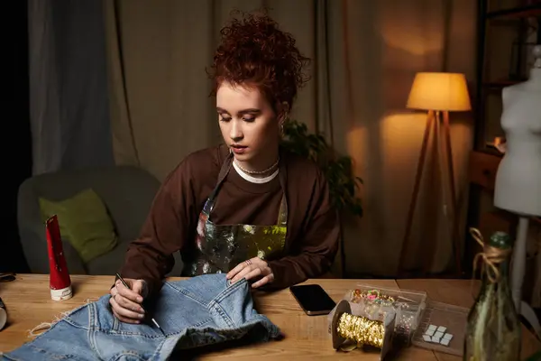 A young artist brings her vision to life by customizing denim in her creative space. — Stock Photo