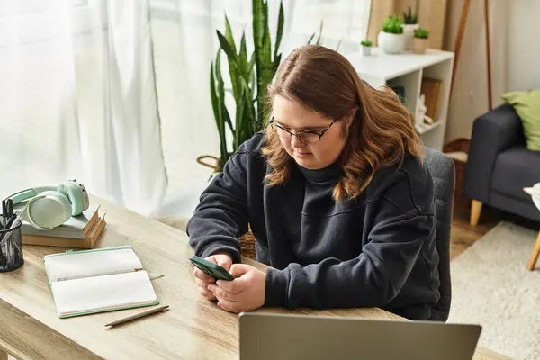 Una giovane donna con sindrome di Down si rilassa a casa, usando il suo smartphone su una scrivania di legno. — Stock Photo