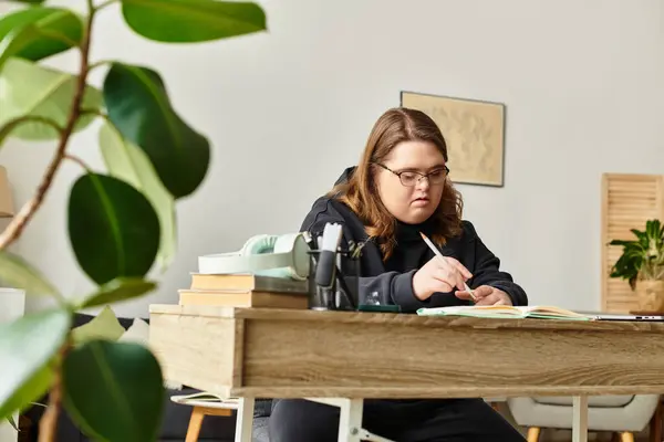 A young woman with Down syndrome enjoys crafting at her home, surrounded by comfort and creativity. — Stock Photo