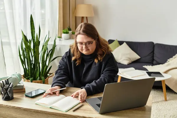 En una casa acogedora, una joven con síndrome de Down estudia atentamente, irradiando confianza. - foto de stock