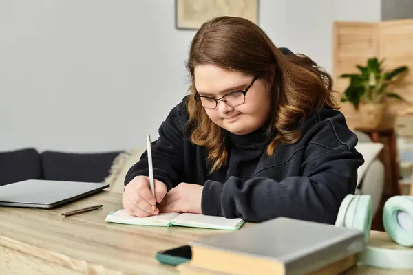 Cozy space hosts a young woman with Down syndrome expressing herself as she writes in a notebook. — Stock Photo