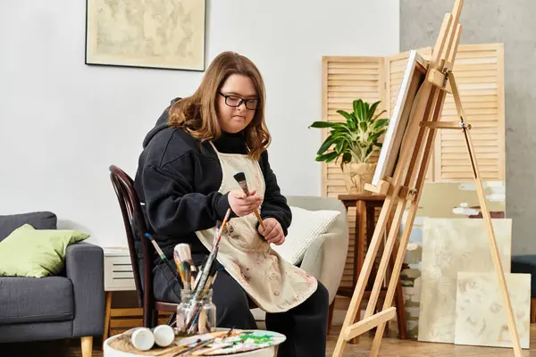 In a cozy setting, a confident young woman with Down syndrome showcases her artistic talent. — Stock Photo
