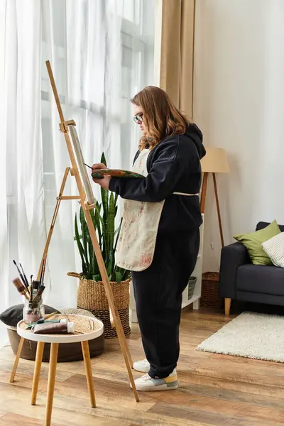 A cozy home where a young woman with Down syndrome happily paints at her easel. — Stock Photo