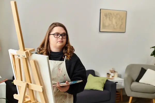 A young woman with Down syndrome shares her creativity while painting in a cozy home. — Stock Photo