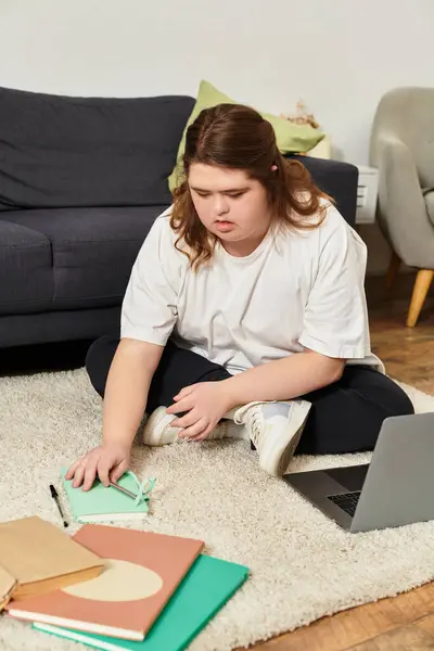 Una giovane donna con la sindrome di Down si concentra sui suoi compiti creativi, mentre circondato da comfort a casa. — Foto stock