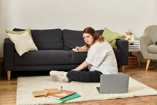 A young woman with Down syndrome engages in creative writing while sitting comfortably at home. — Stock Photo