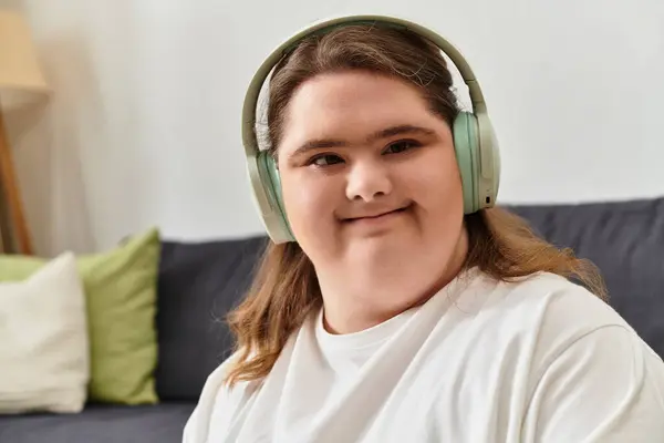 Confident young woman with Down syndrome enjoys music at home in comfy attire. — Stock Photo