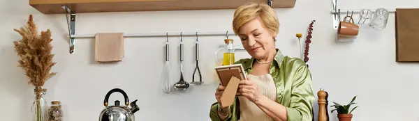 A warm, inviting kitchen where a joyful senior woman writes, capturing special moments. — Stock Photo