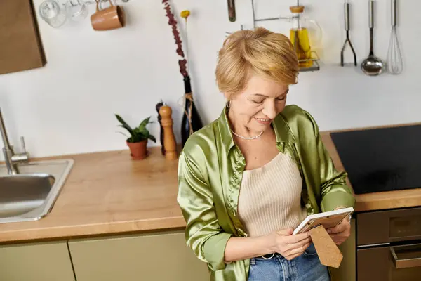 Senior woman with a radiant smile enjoys a fun activity in her bright, green filled kitchen. — Stock Photo