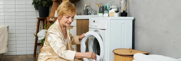 Schöne Seniorin überprüft fröhlich ihre Wäsche, während sie einen aufgeräumten und stilvollen Raum genießt — Stockfoto