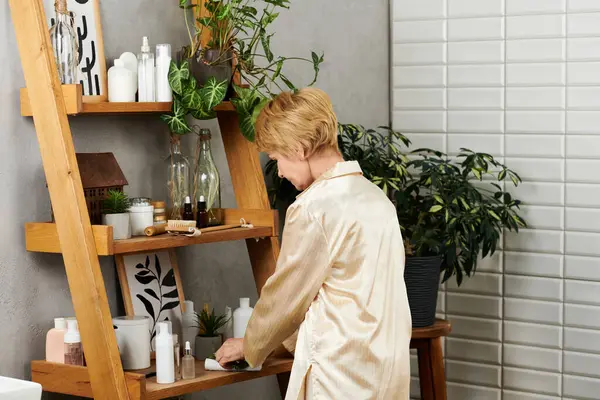 In a serene setting, a lovely senior woman enjoys her soothing skincare ritual in nature. — Stock Photo