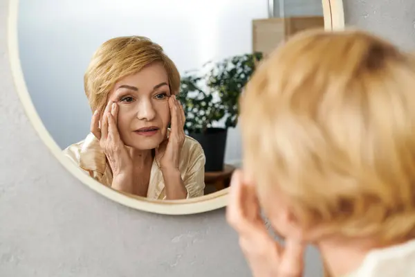 In einem ruhigen Rahmen bewundert eine reizende Seniorin nachdenklich ihre anmutige Reife. — Stockfoto