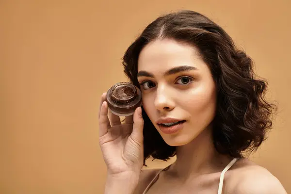 Eine hübsche junge Frau demonstriert ihre Hautpflege, während sie ihr gesundes Leuchten hervorhebt. — Stockfoto