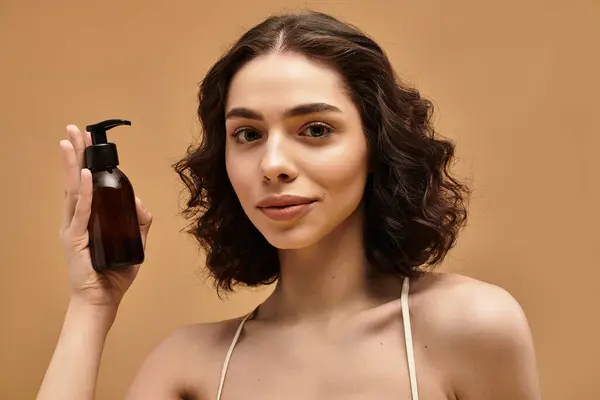 Una giovane donna dimostra detergente facciale nella sua routine di cura della pelle, sorridendo con fiducia — Foto stock