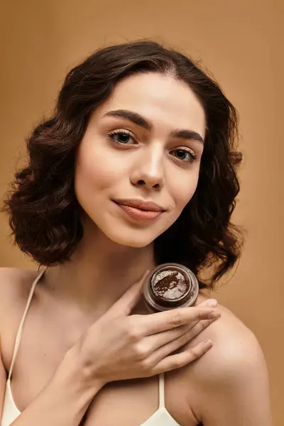 In a studio, a young woman demonstrates her skincare routine while smiling. — Stock Photo