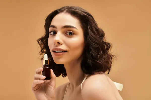 A young woman highlights her skincare routine while smiling, showcasing beauty products in a studio. — Stock Photo