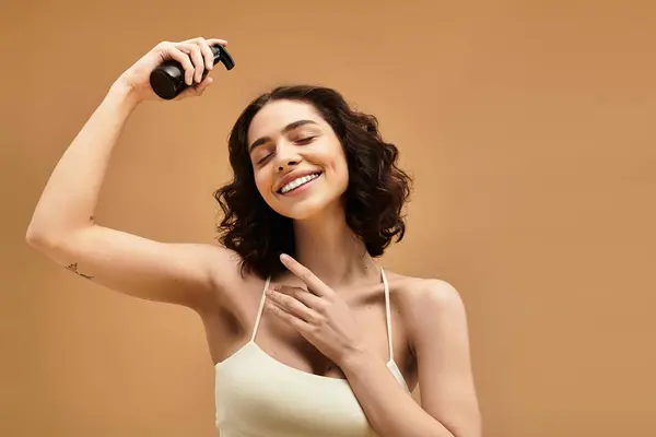 A pretty young woman with braces happily demonstrates her skincare routine in a bright studio. — Stock Photo