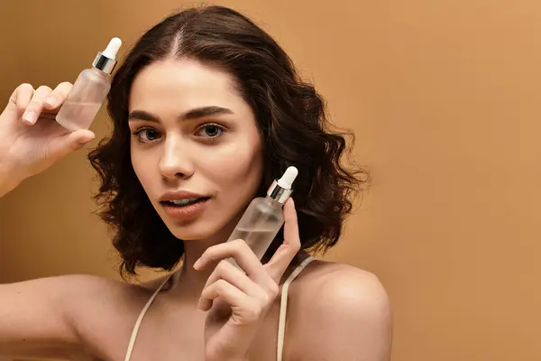 Charming young woman with braces highlights her skincare products in a warm studio environment. — Stock Photo