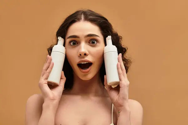 Excited young woman showcases skincare products, highlighting her beauty routine. — Stock Photo