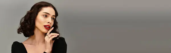 A young woman with red lips and braces poses thoughtfully against a grey backdrop, banner — Stock Photo