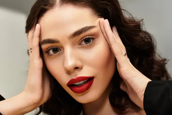 A young woman showcases her beauty with bold red lips, creating a captivating look. — Stock Photo