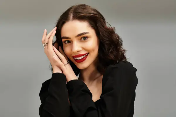 A confident woman shines with red lips and cute braces against a soft background. — Stock Photo