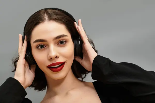 Uma bela jovem vestindo aparelho ouve música, mostrando seus lábios vermelhos vibrantes. — Fotografia de Stock