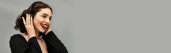 Eine schöne junge Frau mit Zahnspange lächelt strahlend, während sie Kopfhörer trägt, Musik genießt, Banner — Stockfoto