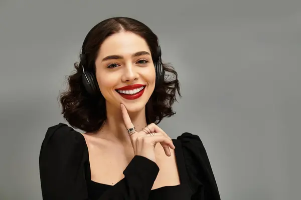 A young woman with braces smiles confidently, her vibrant red lips pop against a grey background. — Stock Photo