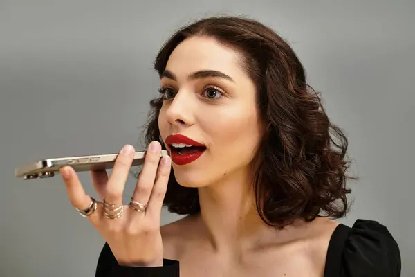 Eine charmante junge Frau mit Zahnspange lächelt strahlend, während sie in ihr Smartphone spricht. — Stockfoto