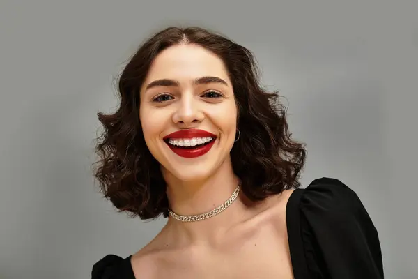 A young woman exudes confidence with her vibrant red lips and charming braces while smiling. — Stock Photo
