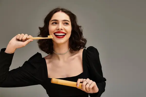 Young woman showcases beautiful smile with braces while holding a bamboo toothbrush happily. — Stock Photo
