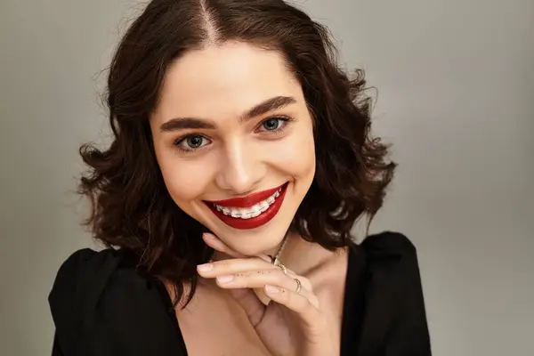 A beautiful young woman with braces and red lips smiles warmly, radiating confidence. — Stock Photo
