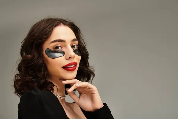A young woman with stunning red lips and braces poses confidently against a soft grey background. — Stock Photo