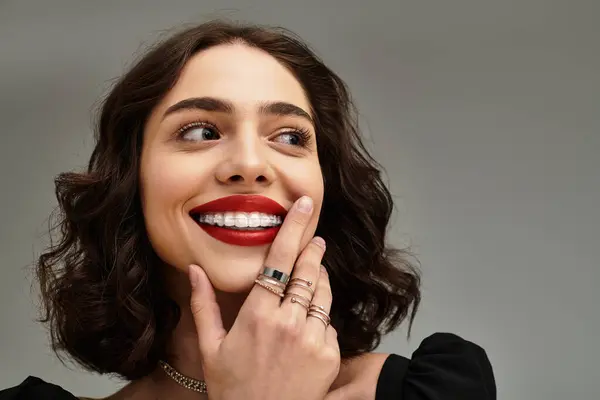 A young woman with braces and red lips flashes a captivating smile while posing elegantly. — Stock Photo