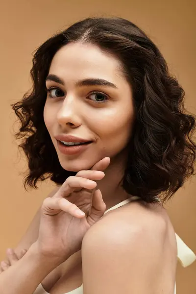 Uma jovem bonita com aparelho mostrando sua rotina de cuidados com a pele em um estúdio, irradiando confiança. — Fotografia de Stock