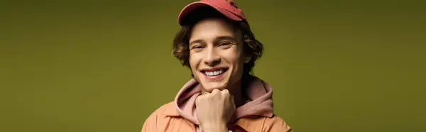 Trendy young man smiles confidently in stylish attire against a colorful backdrop. — Stock Photo