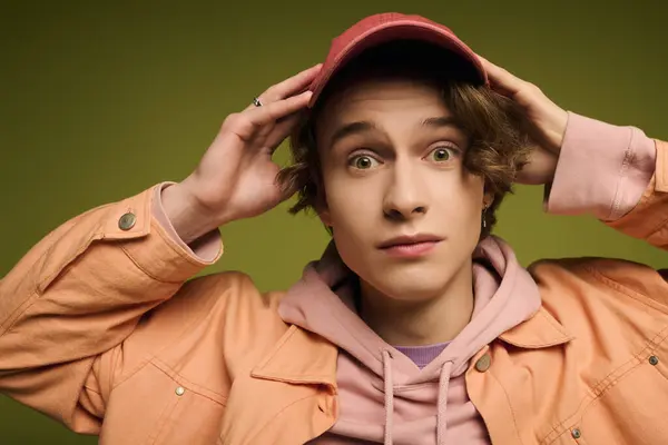 Young man in stylish attire expresses surprise while posing against a colorful backdrop — Stock Photo