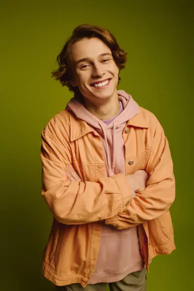 Confident young man showcases trendy attire with a warm smile, reflecting modern youth culture. — Stock Photo