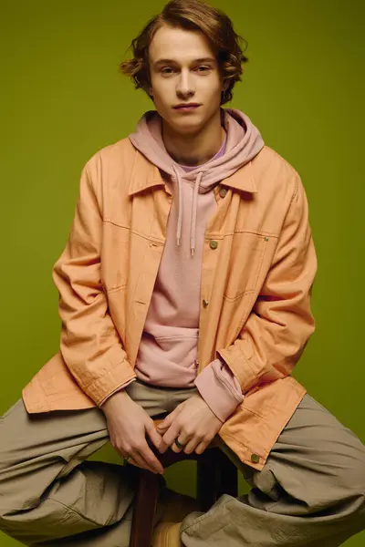 Young man confidently showcases trendy fashion against a vibrant backdrop. — Stock Photo
