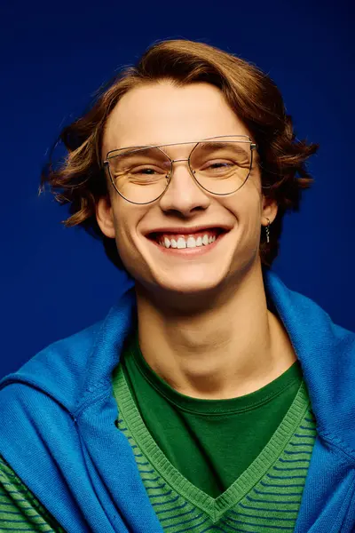 A young man in trendy clothes and stylish glasses radiates confidence and joy. — Stock Photo