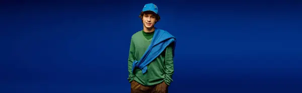 A young man stands confidently in fashionable attire, radiating modern youth culture and style. — Stock Photo