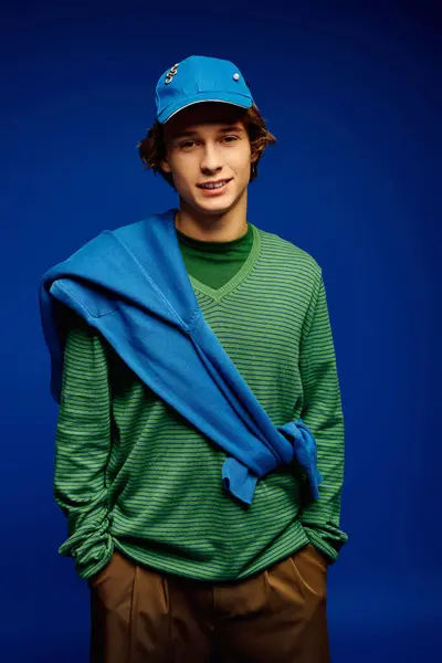 Young man with stylish attire exudes confidence as he poses in a modern, vibrant environment. — Stock Photo